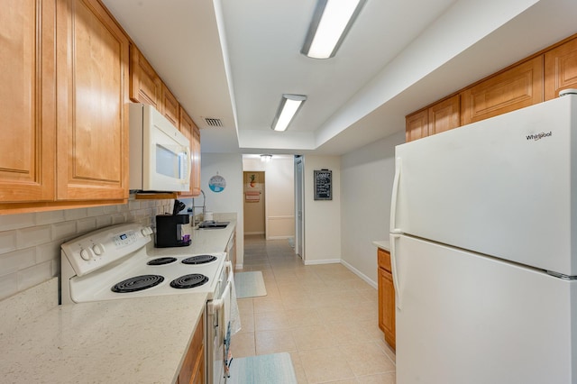 kitchen featuring decorative backsplash, sink, light tile patterned floors, and white appliances