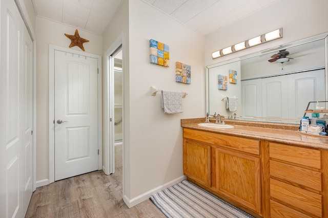 bathroom with hardwood / wood-style floors, vanity, and ceiling fan