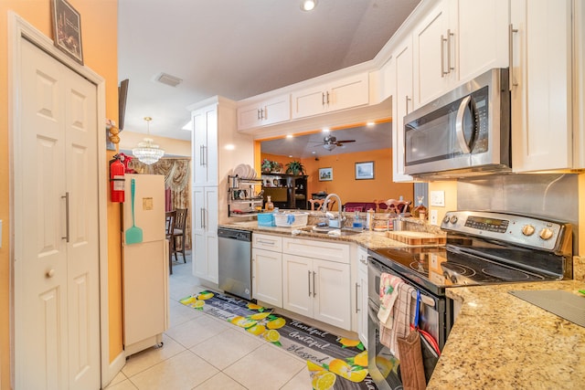 kitchen featuring white cabinetry, stainless steel appliances, light stone counters, light tile flooring, and ceiling fan