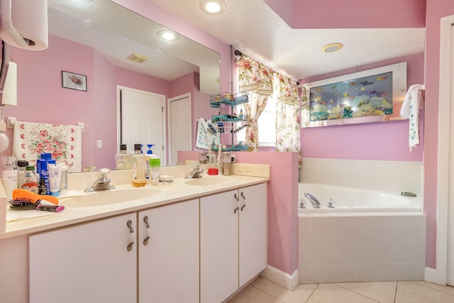 bathroom featuring a relaxing tiled bath, dual vanity, a textured ceiling, and tile floors