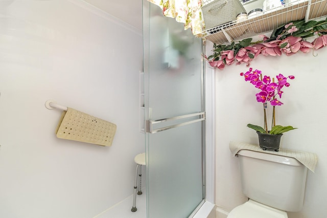 bathroom with an enclosed shower, ornamental molding, and toilet