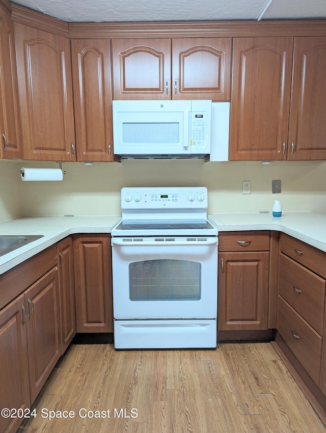 kitchen with light wood-type flooring and white appliances