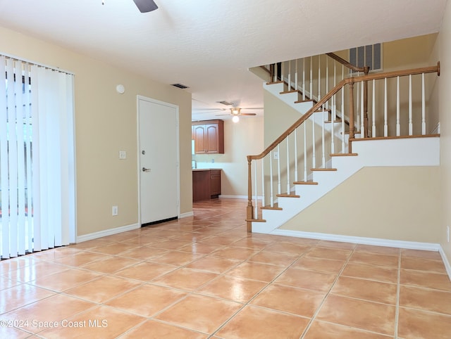 interior space featuring tile patterned flooring, a textured ceiling, and ceiling fan