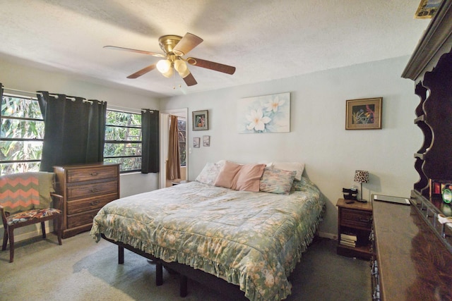 carpeted bedroom featuring a textured ceiling and ceiling fan