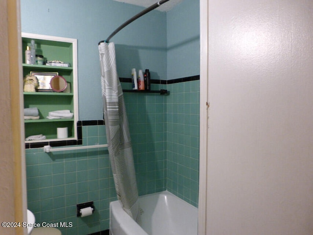 bathroom with toilet, tile walls, and shower / tub combo