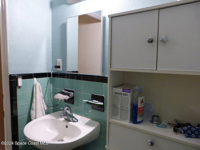 bathroom with tile walls and sink