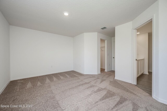 carpeted empty room with a textured ceiling