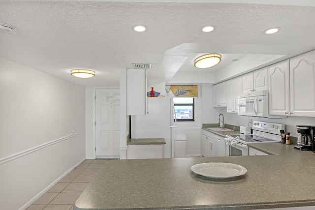 kitchen featuring white appliances, white cabinets, sink, a textured ceiling, and light tile patterned flooring