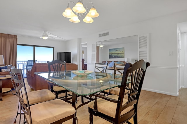 dining area with ceiling fan with notable chandelier and light hardwood / wood-style floors