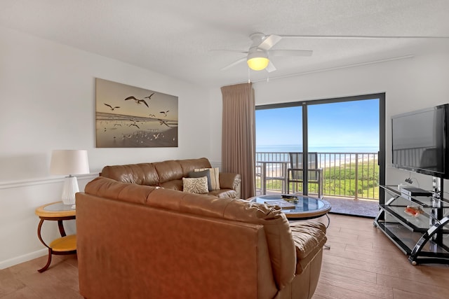 living room featuring a textured ceiling, hardwood / wood-style flooring, and ceiling fan