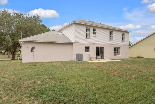 rear view of house featuring a patio area, a yard, and central AC