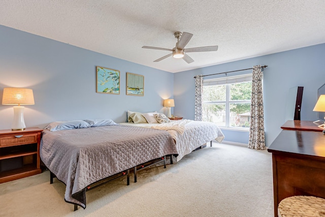 carpeted bedroom featuring a textured ceiling and ceiling fan