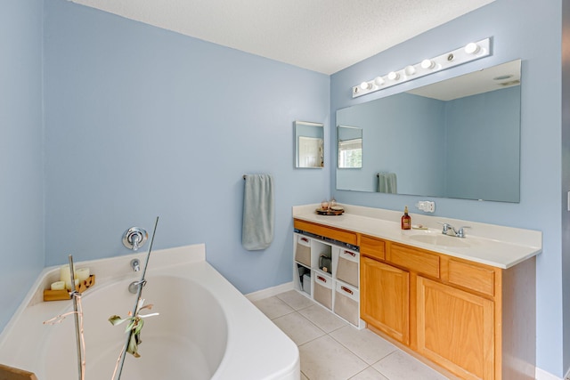 bathroom featuring a bathing tub, vanity, a textured ceiling, and tile patterned floors