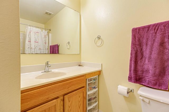 bathroom with vanity, a shower with shower curtain, and toilet