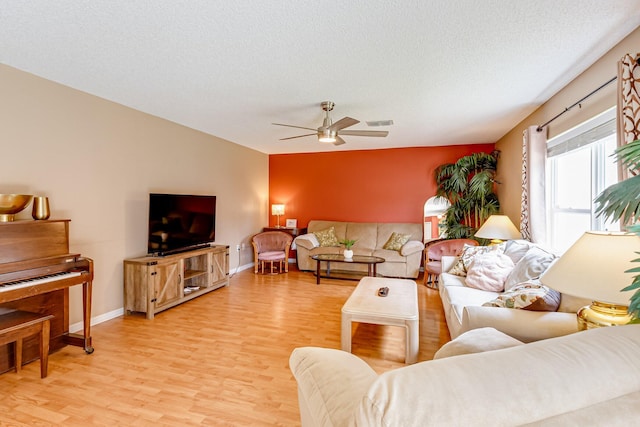 living room featuring ceiling fan, wood-type flooring, and a textured ceiling