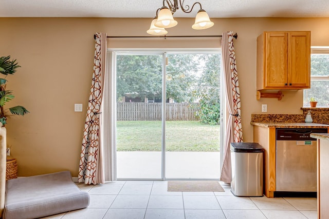 entryway with plenty of natural light, light tile patterned floors, and a notable chandelier