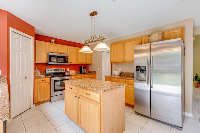 kitchen with a center island, light tile patterned floors, a textured ceiling, decorative light fixtures, and stainless steel appliances