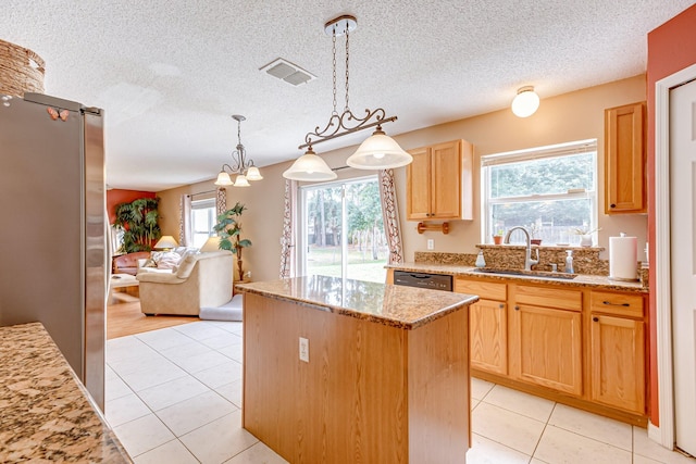 kitchen featuring sink, a center island, light stone counters, a textured ceiling, and decorative light fixtures