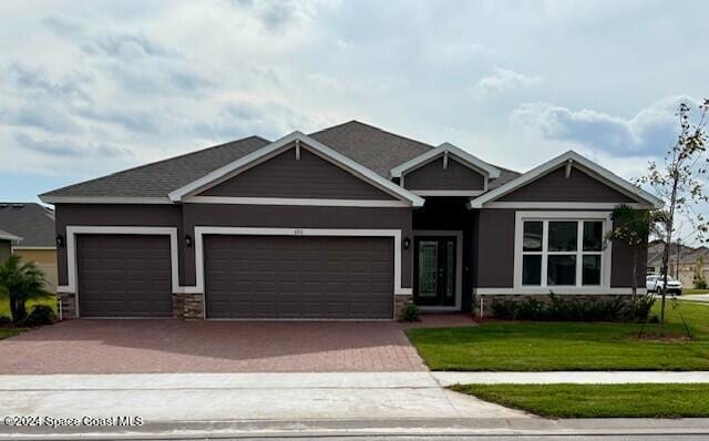 craftsman inspired home with a garage and a front yard