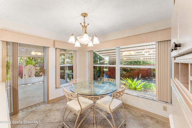 dining room with baseboards, a textured ceiling, and an inviting chandelier
