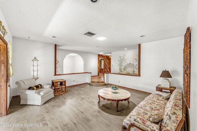 living room featuring a textured ceiling and light wood-type flooring