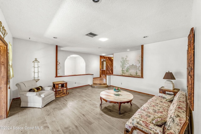 living area with a textured ceiling, recessed lighting, baseboards, wood finished floors, and visible vents
