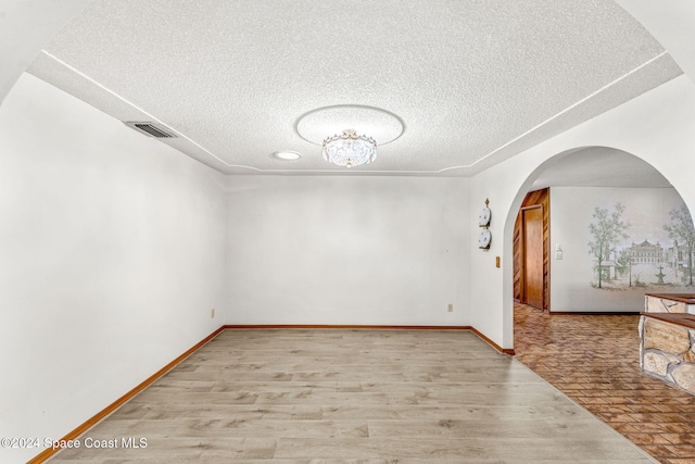 spare room featuring a textured ceiling and light wood-type flooring