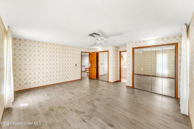 unfurnished bedroom featuring a closet, a textured ceiling, hardwood / wood-style flooring, and ceiling fan