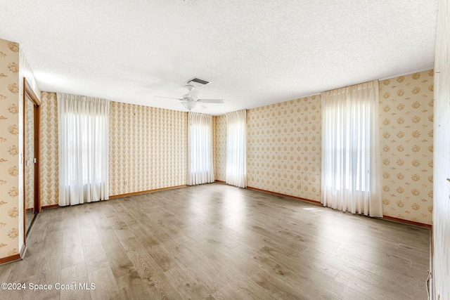 unfurnished room featuring hardwood / wood-style floors, a textured ceiling, and ceiling fan