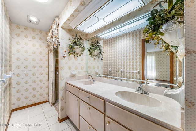 full bathroom with tile patterned flooring, a sink, double vanity, and wallpapered walls