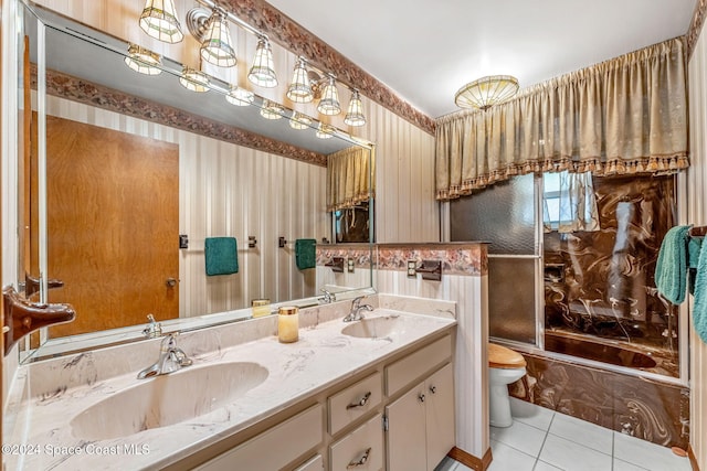 bathroom featuring double vanity, toilet, tile patterned floors, and a sink