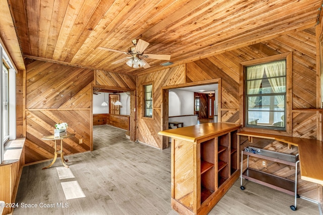 interior space with lofted ceiling, wooden walls, light hardwood / wood-style flooring, wooden ceiling, and ceiling fan