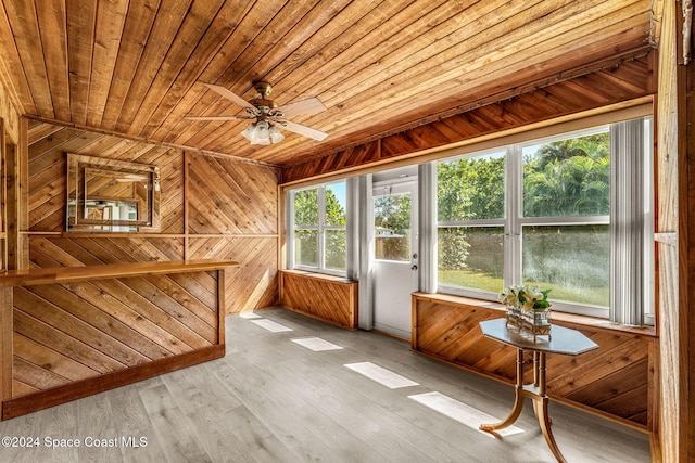 unfurnished sunroom with ceiling fan, wooden ceiling, and plenty of natural light