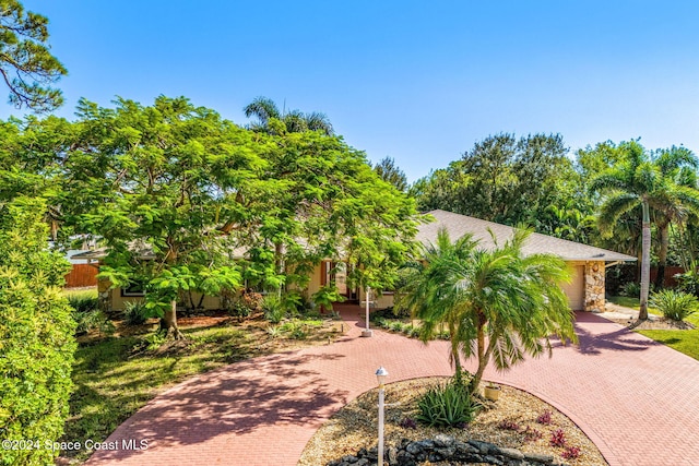 view of community featuring an attached garage and decorative driveway