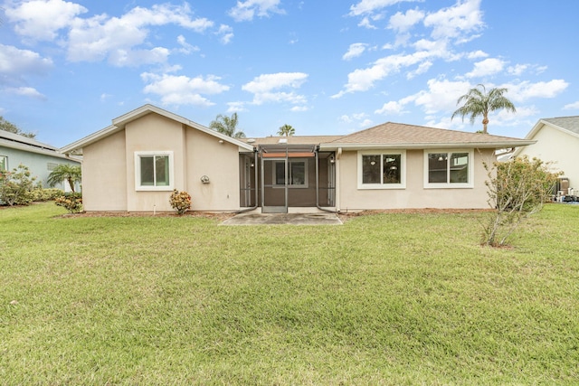 rear view of property with a yard and a sunroom