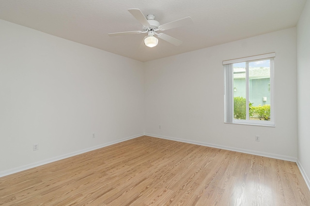 empty room with ceiling fan and light hardwood / wood-style floors