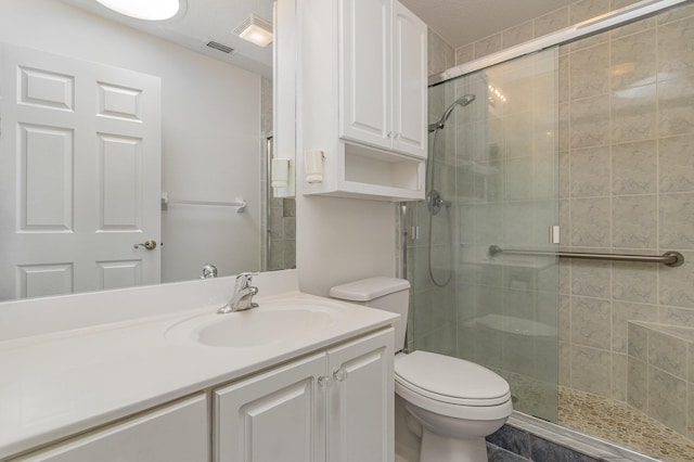 bathroom featuring vanity, an enclosed shower, and toilet