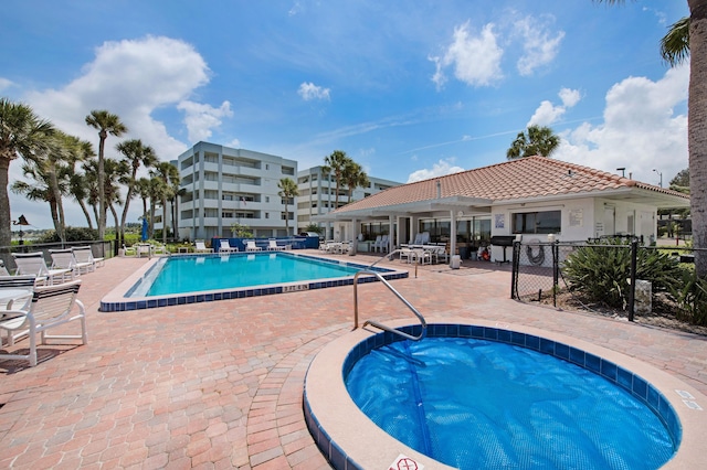 view of pool featuring a community hot tub and a patio