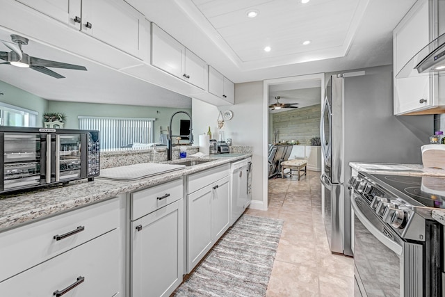 kitchen with stainless steel electric stove, white cabinets, white dishwasher, ceiling fan, and a healthy amount of sunlight