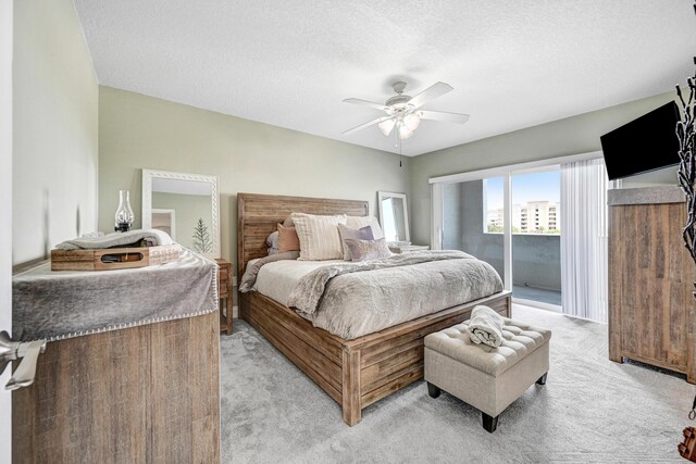 carpeted bedroom with access to exterior, a textured ceiling, and ceiling fan