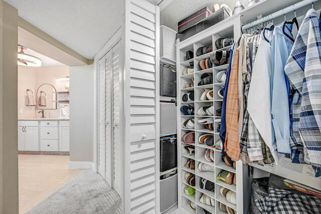 walk in closet with sink and light tile patterned floors