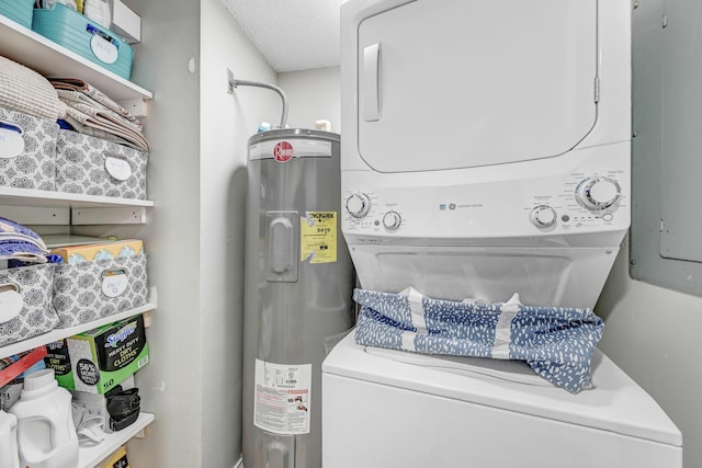 laundry room featuring stacked washer / dryer, a textured ceiling, and water heater