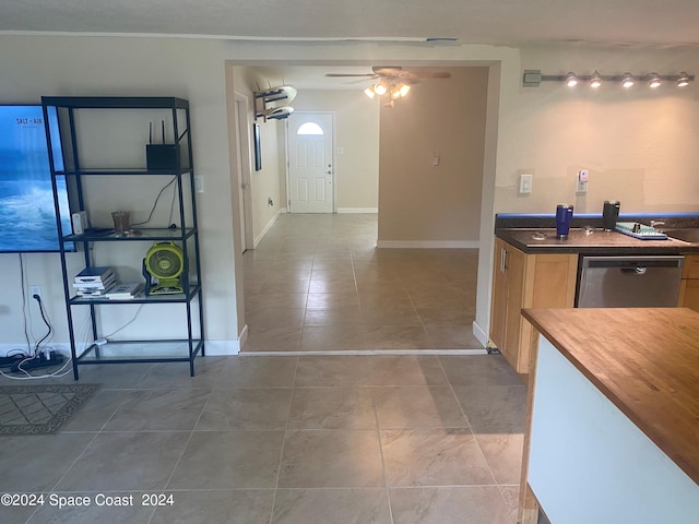 kitchen featuring ceiling fan, light tile patterned flooring, wooden counters, and stainless steel dishwasher