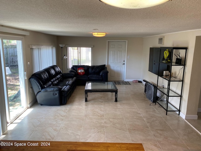 living room featuring a textured ceiling, vaulted ceiling, and light tile patterned flooring