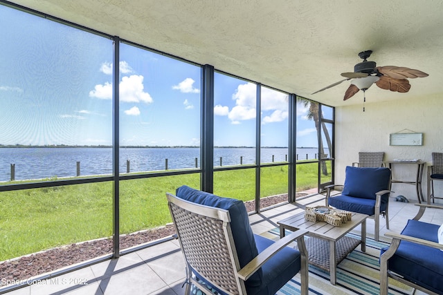 sunroom featuring ceiling fan, a healthy amount of sunlight, and a water view