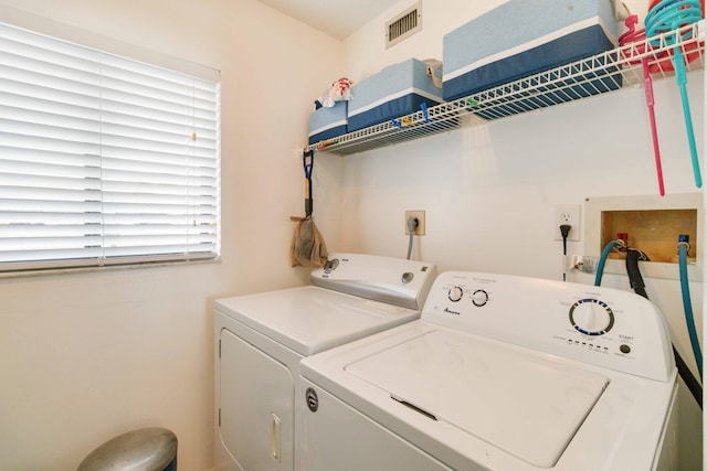clothes washing area featuring separate washer and dryer