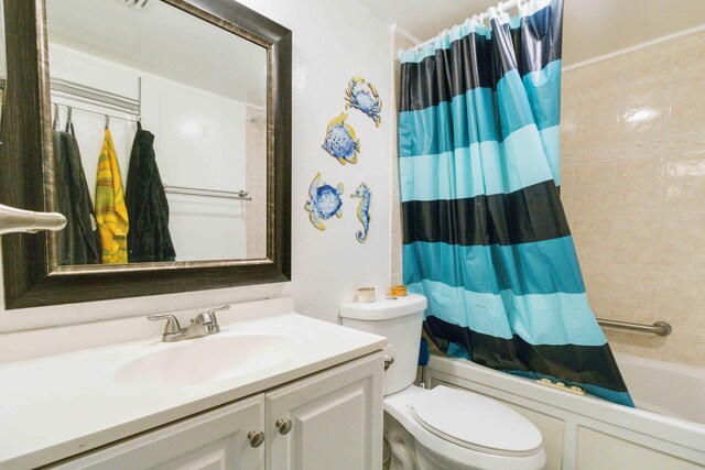 full bathroom with shower / tub combo with curtain, vanity, and toilet
