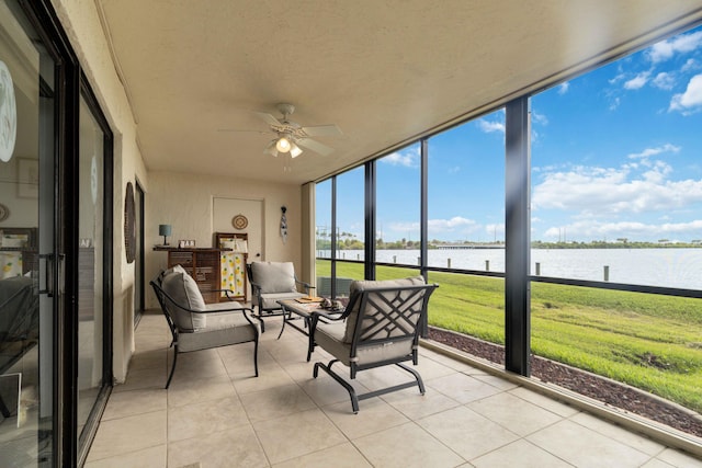 sunroom featuring a water view and ceiling fan