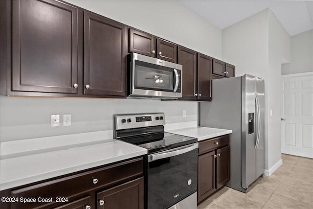 kitchen with stainless steel appliances, dark brown cabinets, and light tile patterned floors