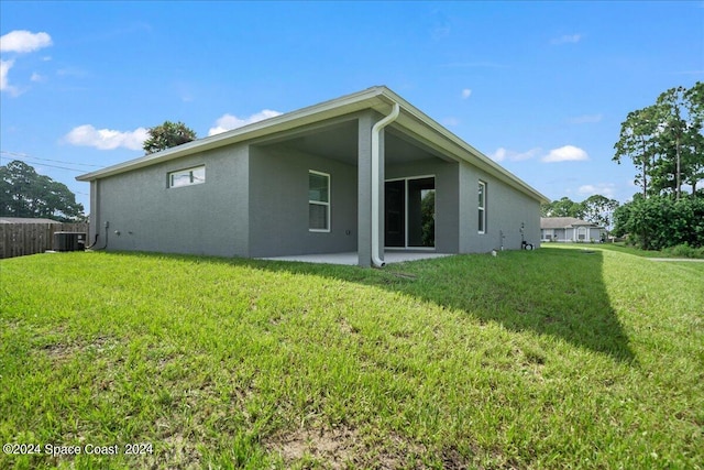 back of house with a lawn, central AC unit, and a patio